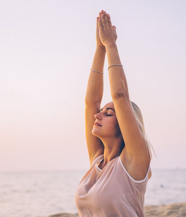 Person meditating peacefully in a natural outdoor setting at sunrise.